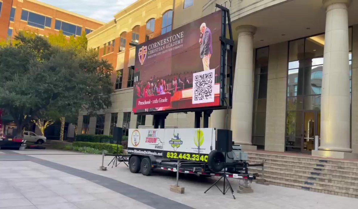 LED screen trailer showing event information in bright daylight